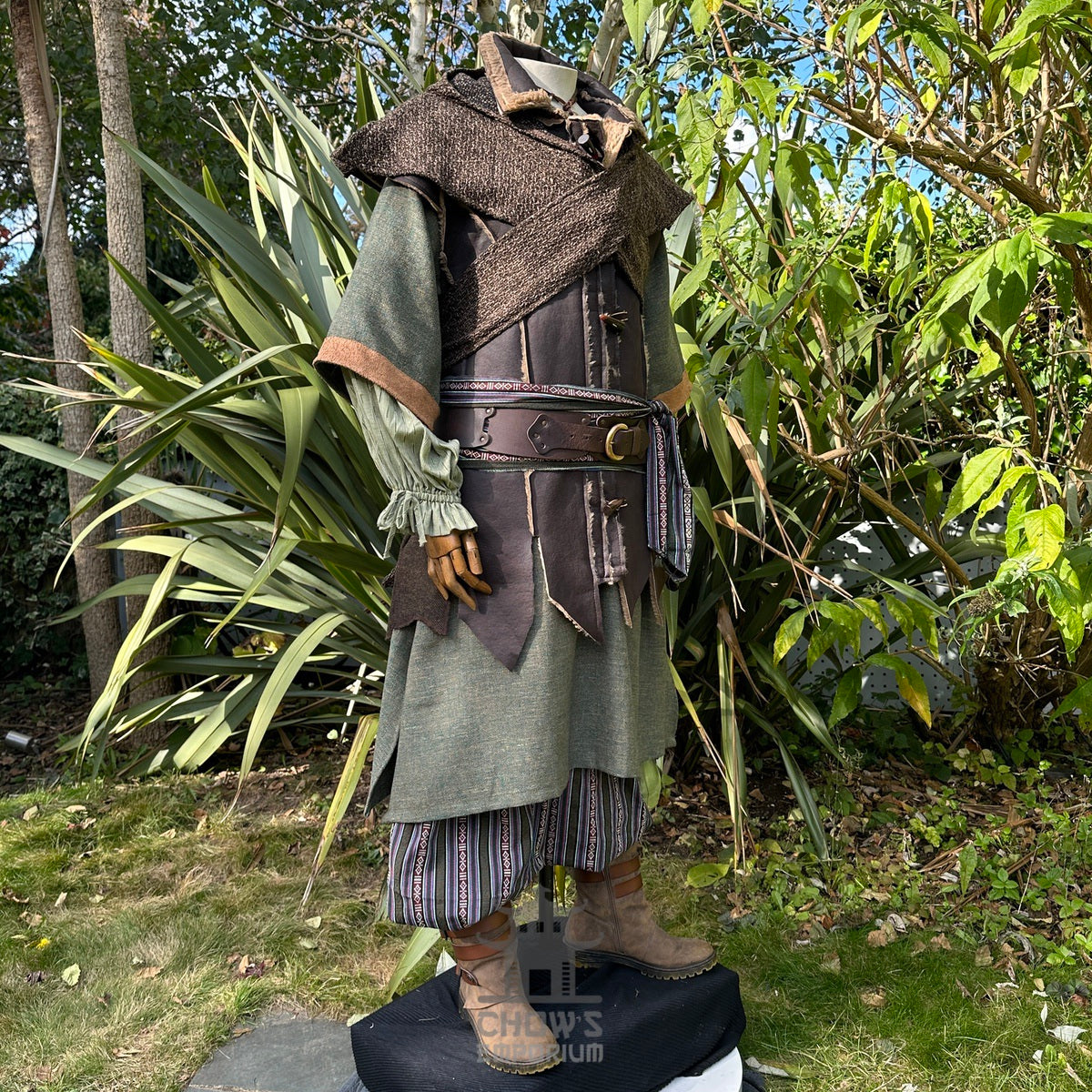 Medieval LARP costume side view, featuring a brown leather waistcoat, tunic, shirt, hood.