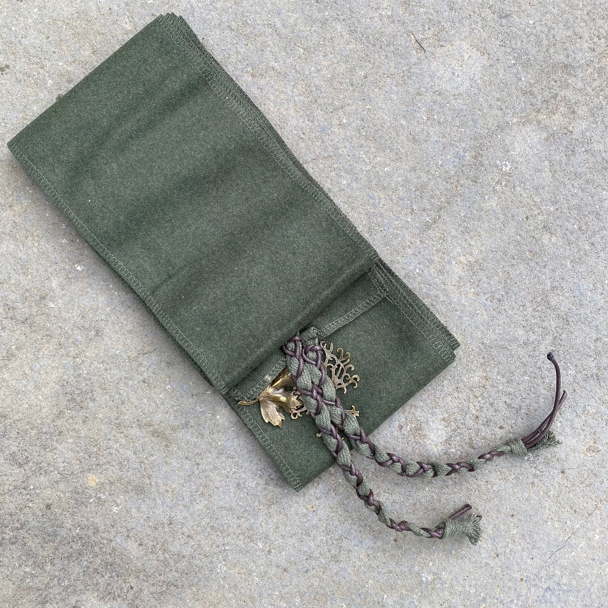Green herringbone arm wrap with braided cord and leaf charm for LARP.