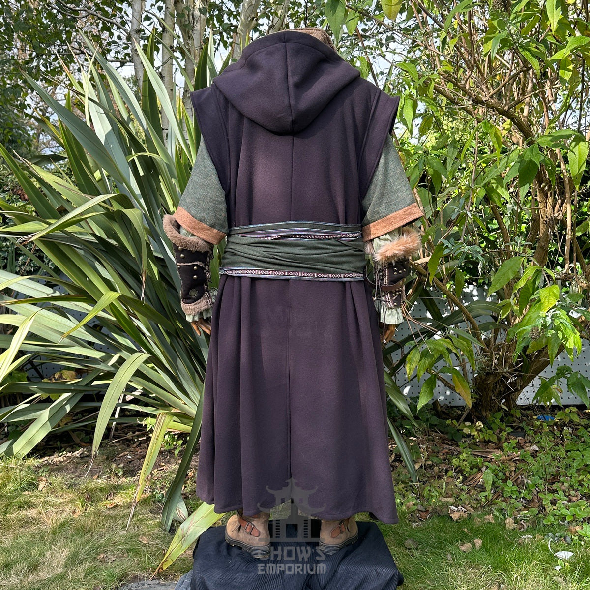 Forest Wanderer LARP outfit, back view, dark robe, green waistcoat, leafy backdrop.