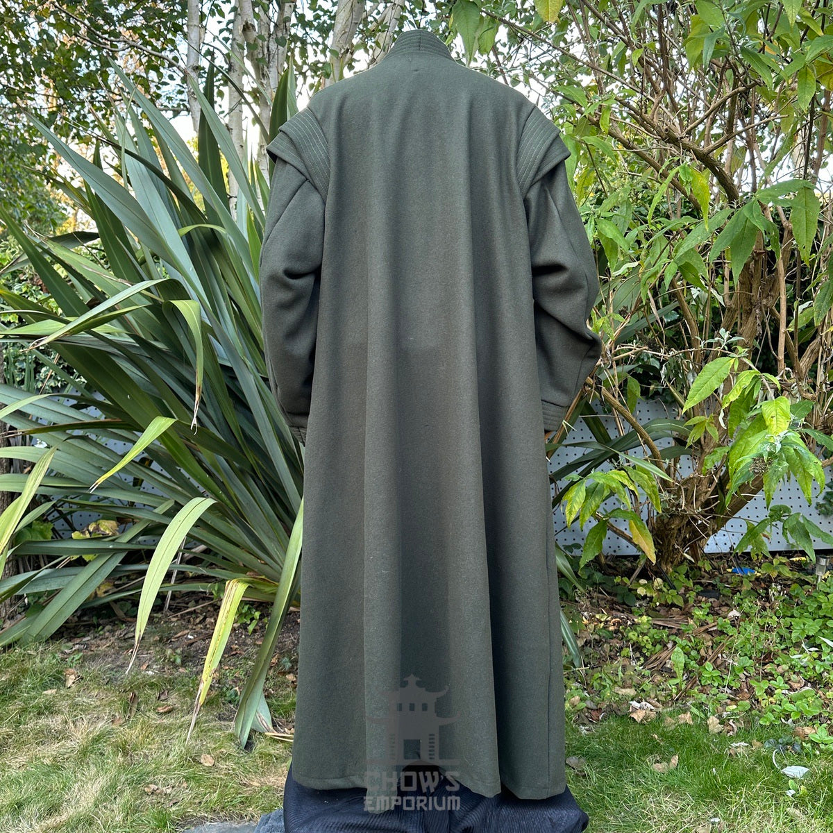 Back view of green medieval LARP robe in garden setting, no belt.
