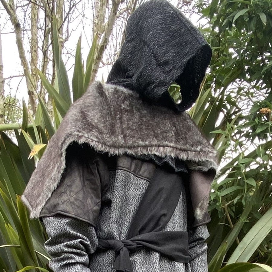 Medieval LARP outfit side view, featuring a grey wrap-around hood, and grey faux-fur mantle. For Renaissance Faire and historical roleplay events.