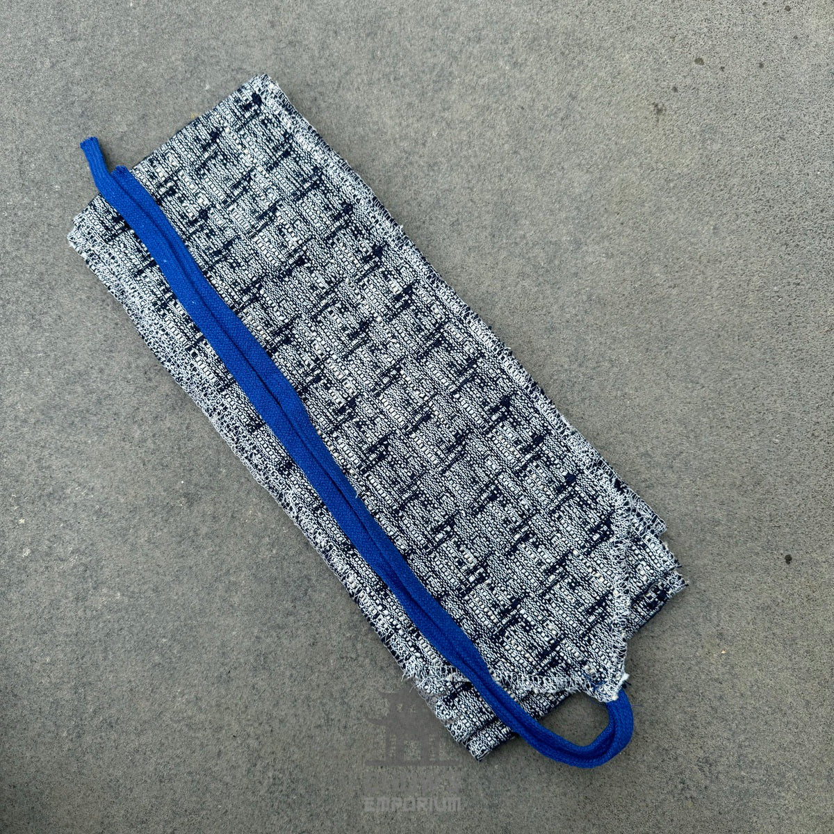 Grey medieval LARP sash with blue trim, folded, textured pattern, fabric visible.