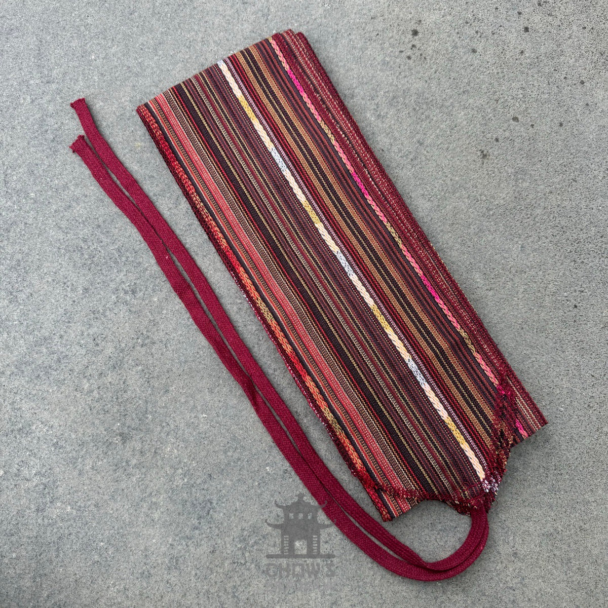 Autumnal striped pirate sash for LARP, woven fabric on grey background.