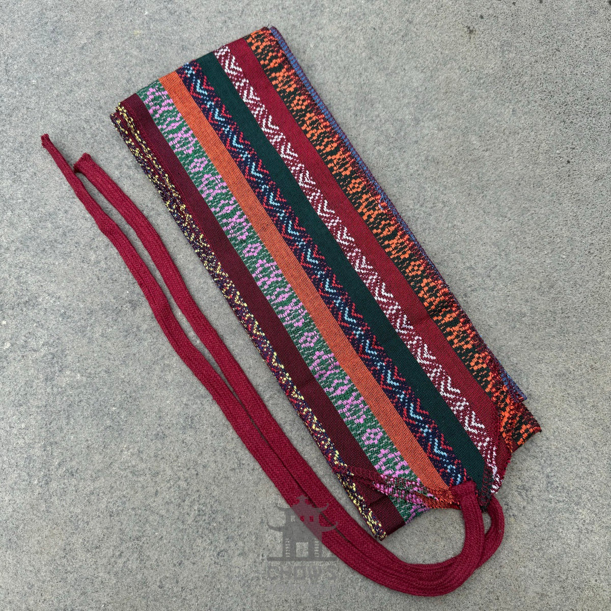 LARP medieval sash, vibrant red and blue pattern, woven fabric, flat lay.