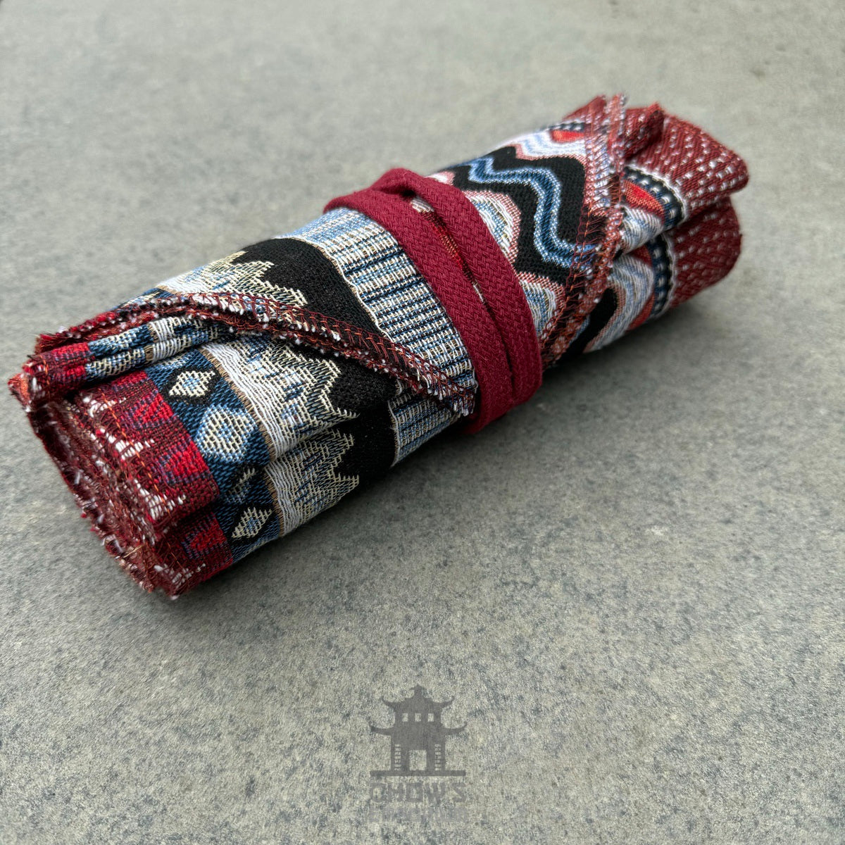 Rolled Nordic zigzag pattern pirate sash, red and blue.