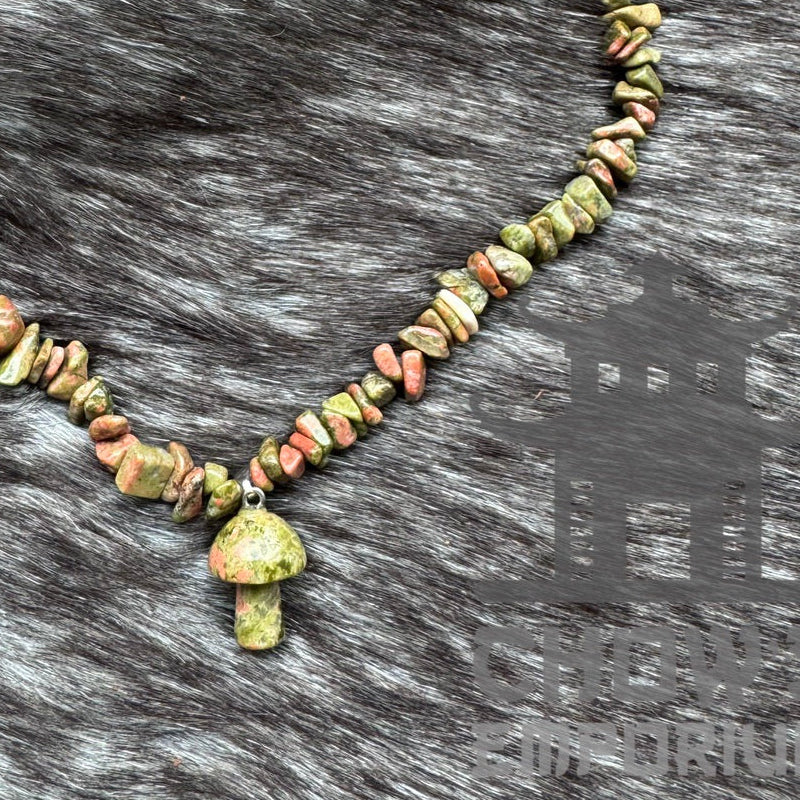 Green polished quartz necklace with mushroom pendant on fur.