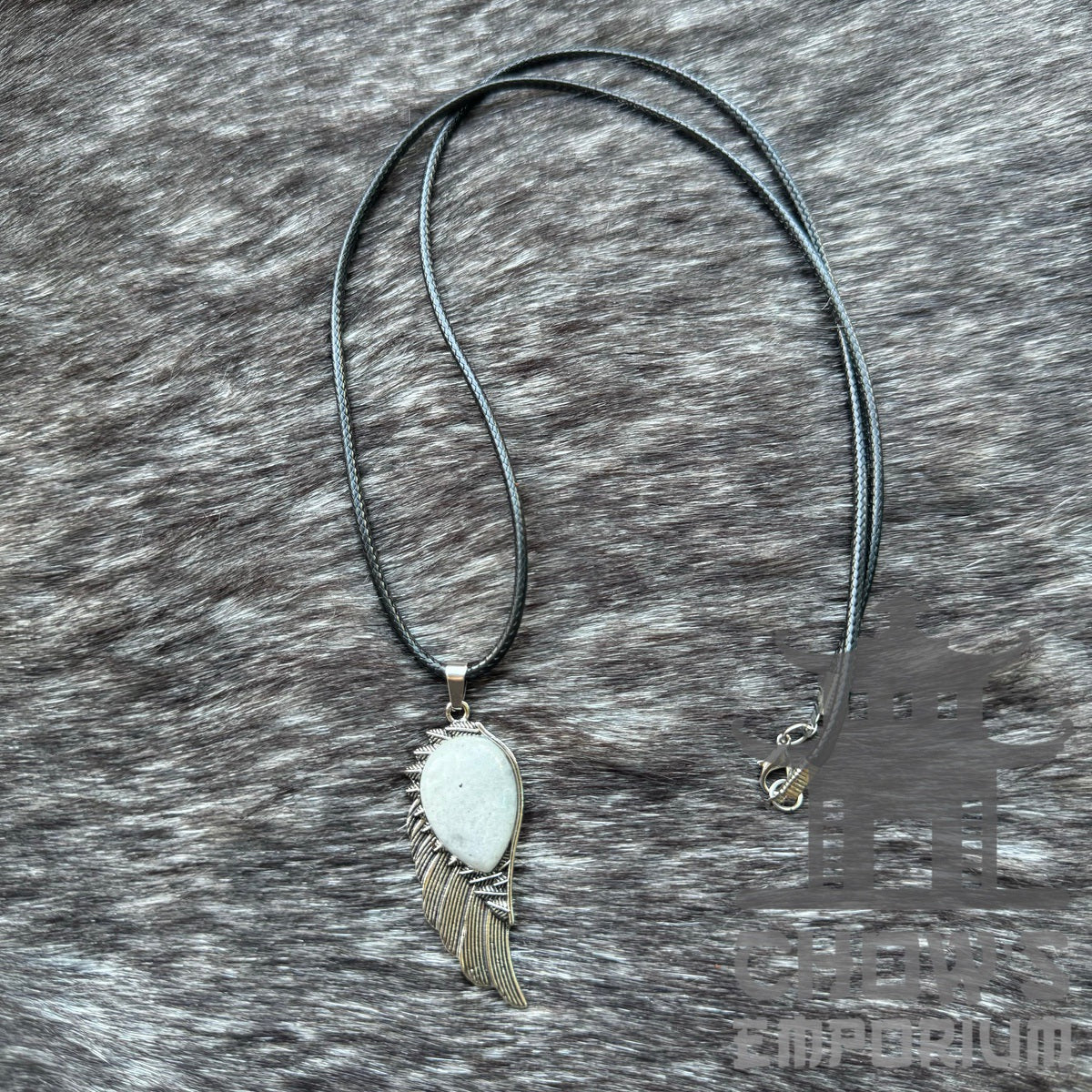 LARP medieval necklace with wing pendant on dark textured fabric backdrop.