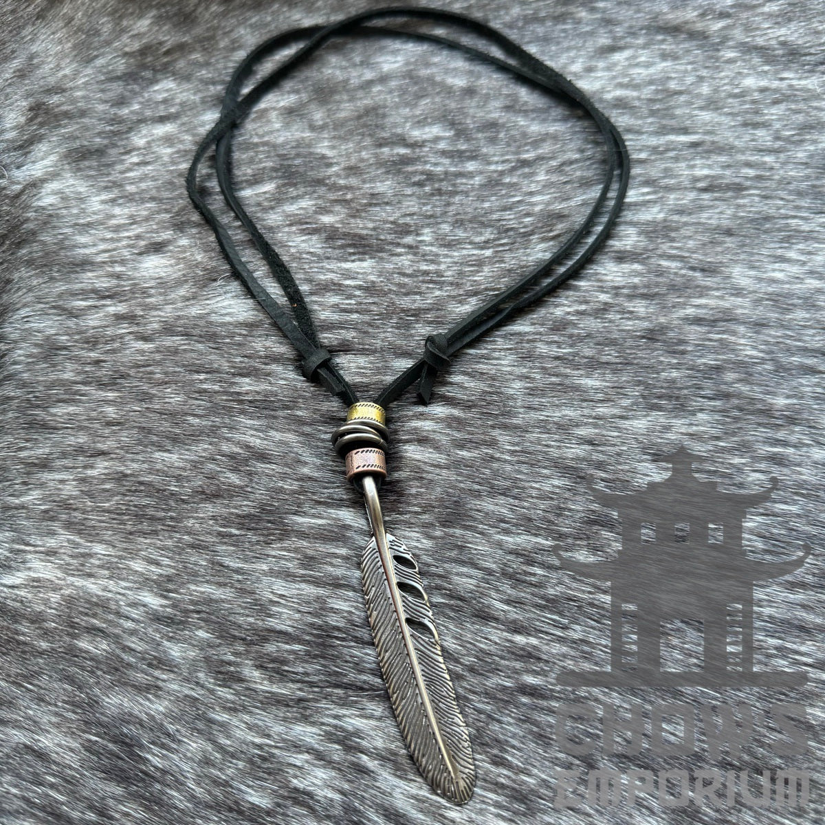 Black feather necklace with silver pendant for LARP, shown on fur background.