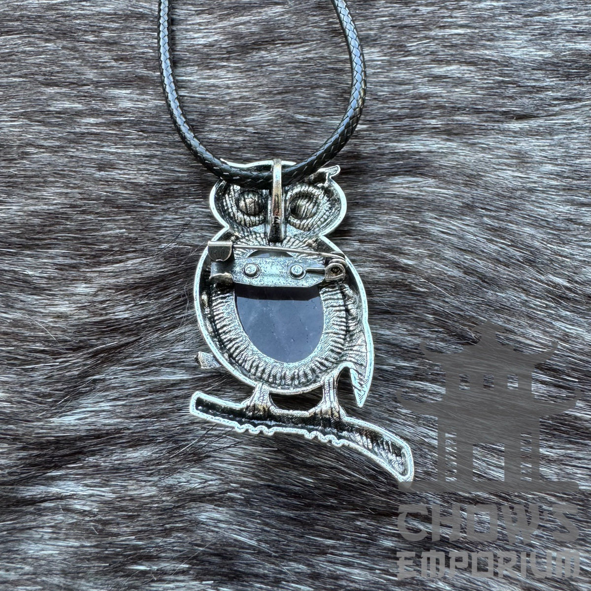 Silver owl pendant with black gem detail for medieval LARP on fur backdrop.