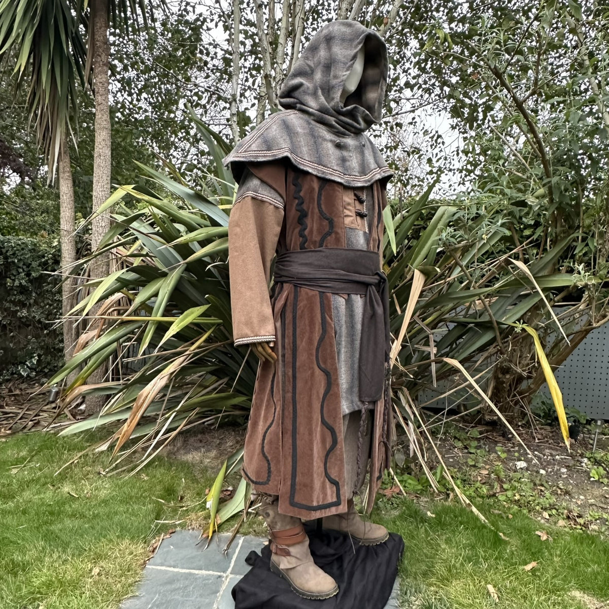 Medieval LARP snood hood, side view, brown and grey with draped arms.