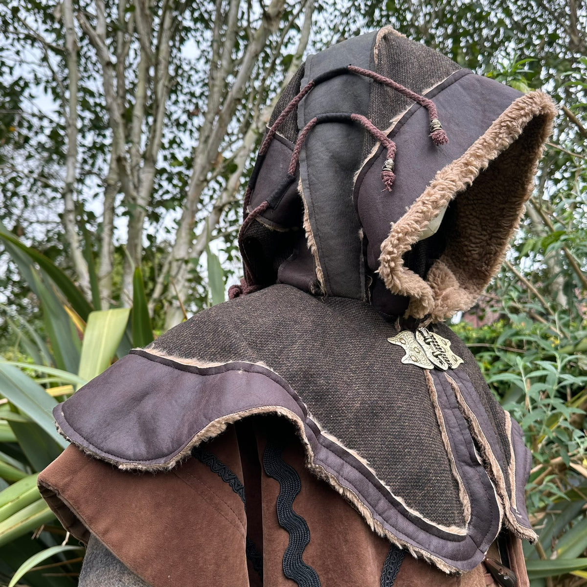 LARP medieval hood side view with layered textures and ornate metal clasp.