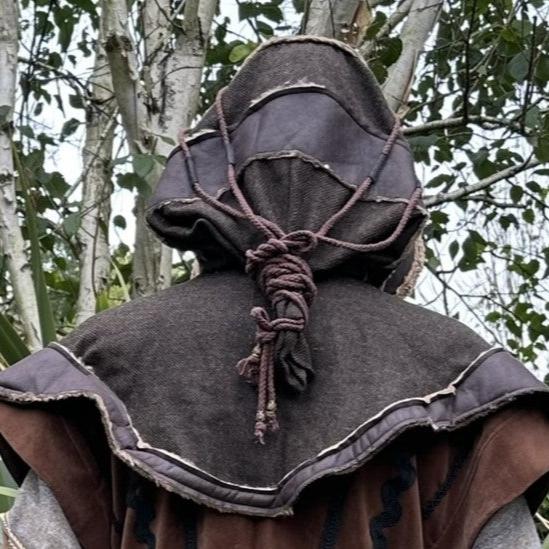 Back view of LARP hood with rope detail, set in a woodland medieval scene.