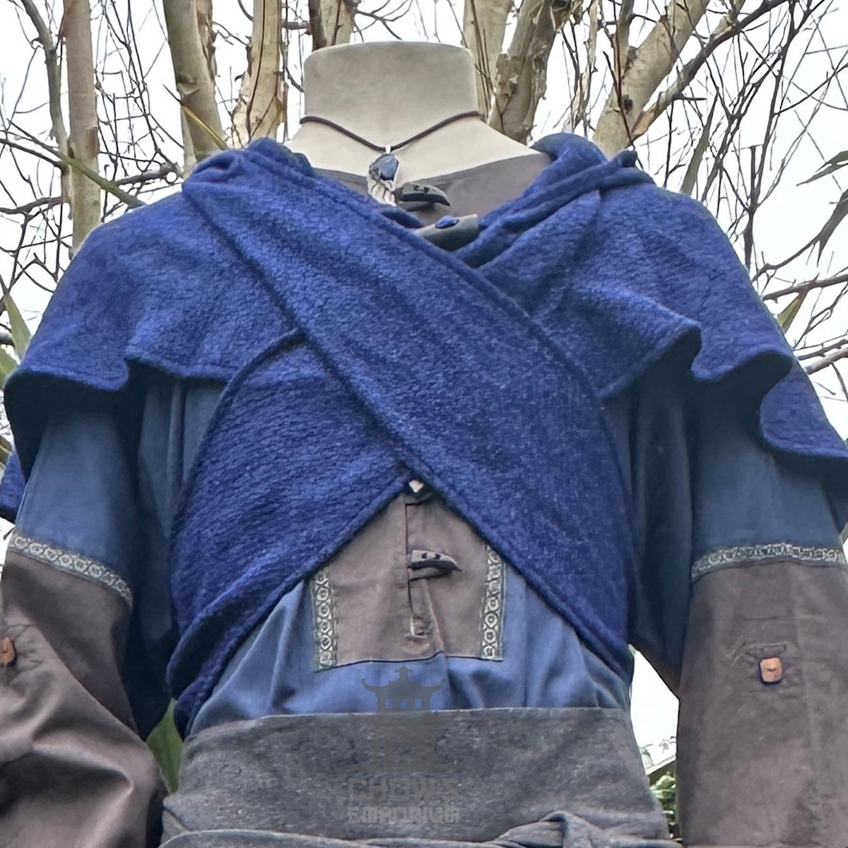 Blue wool scarf hood draped over medieval outfit on mannequin.