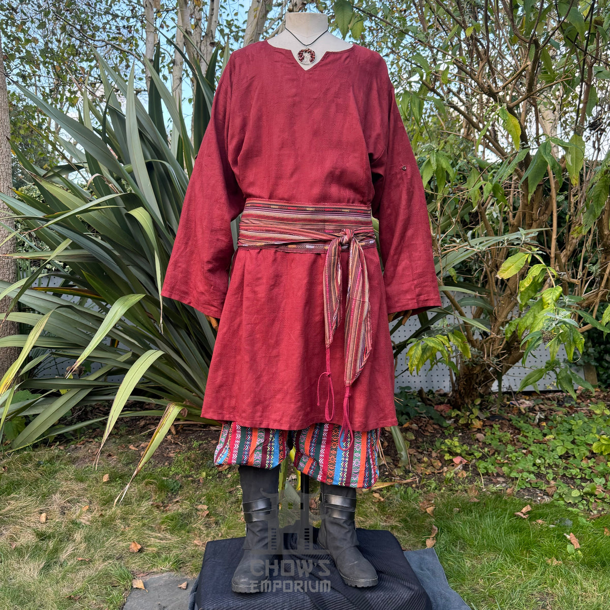 Medieval tunic in red textured cotton, front view, with striped belt.