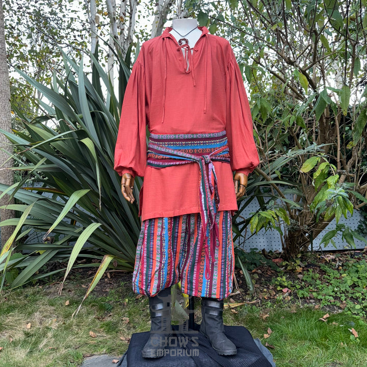 3 piece outfit with orange shirt and multi striped trousers and sash