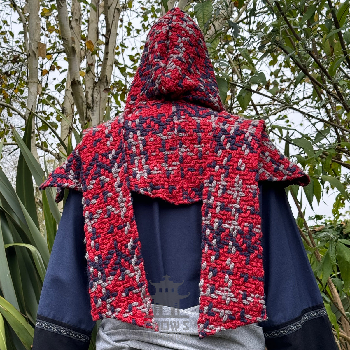 Red tricolour wool LARP scarf hood, back view in a natural setting.