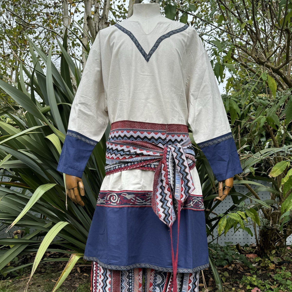 Cream tunic with blue sleeves and patterned sash, LARP costume, back view.