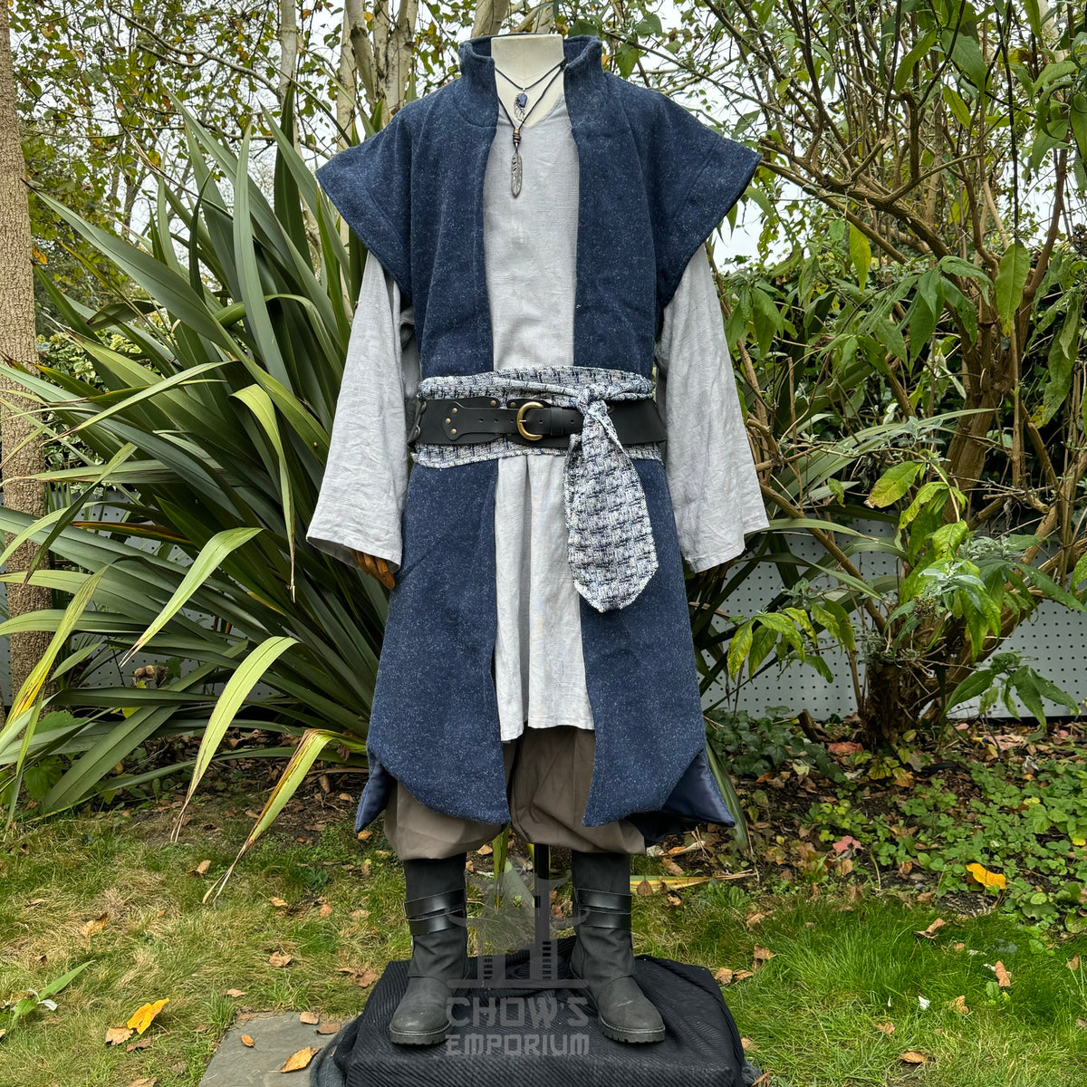 Blue medieval LARP waistcoat front view, layered over grey robe and boots.