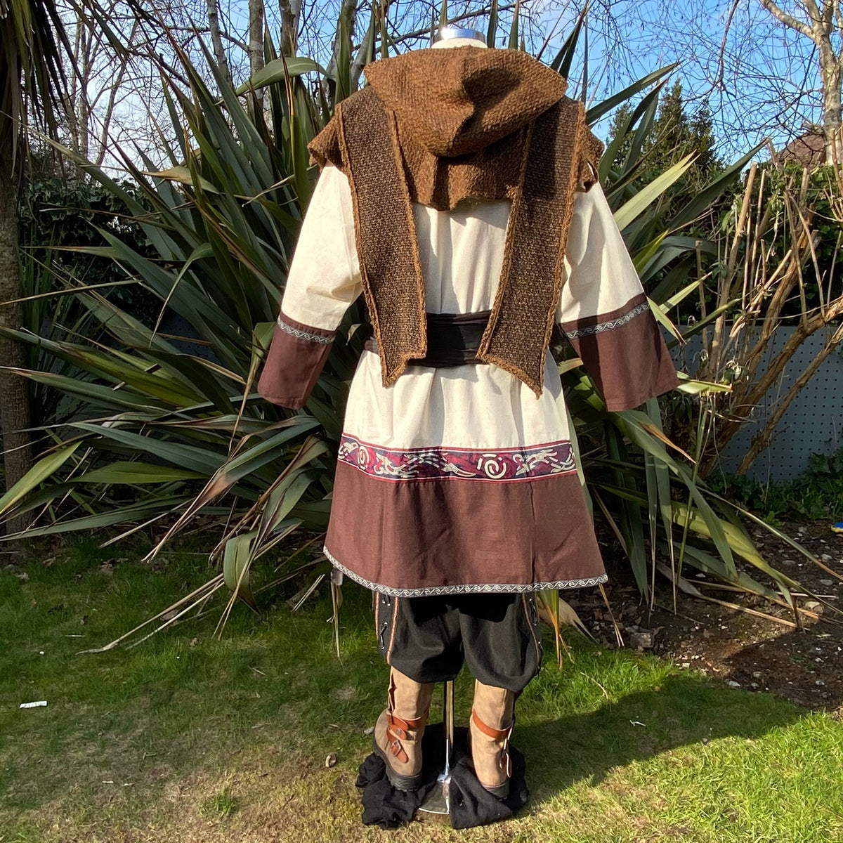 Rear view of medieval LARP outfit with patterned border and brown hood.