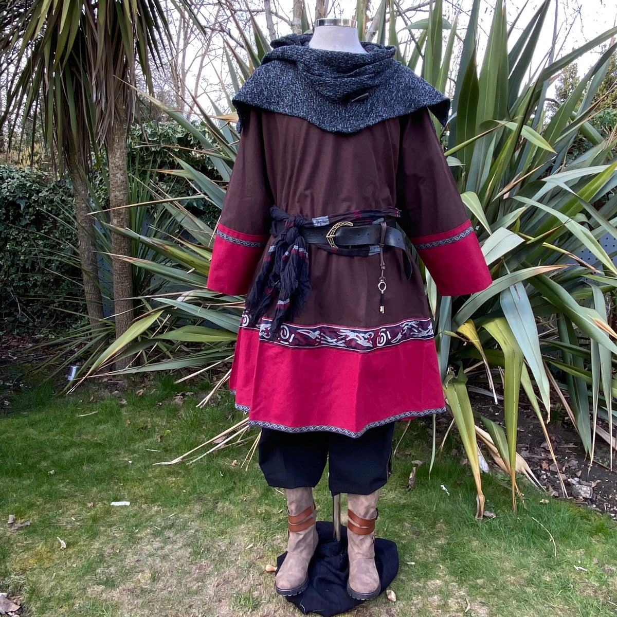 Rear view of LARP outfit with red hem tunic, belt, and hood.