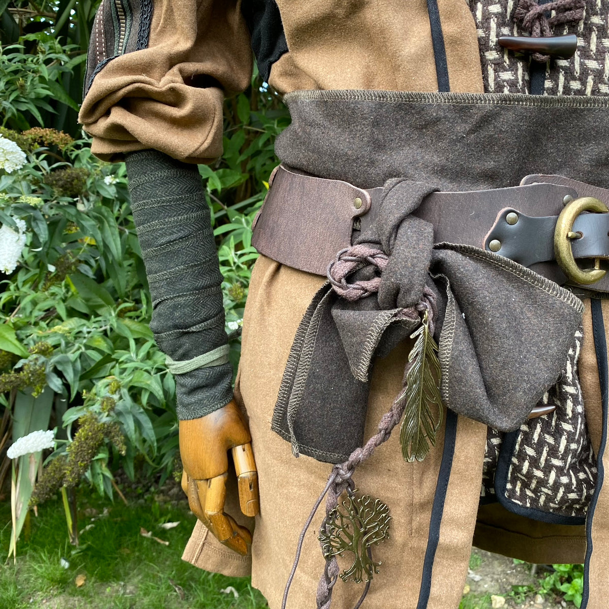 Medieval LARP wrap detail; brown sash with leaf charm and arm wraps.