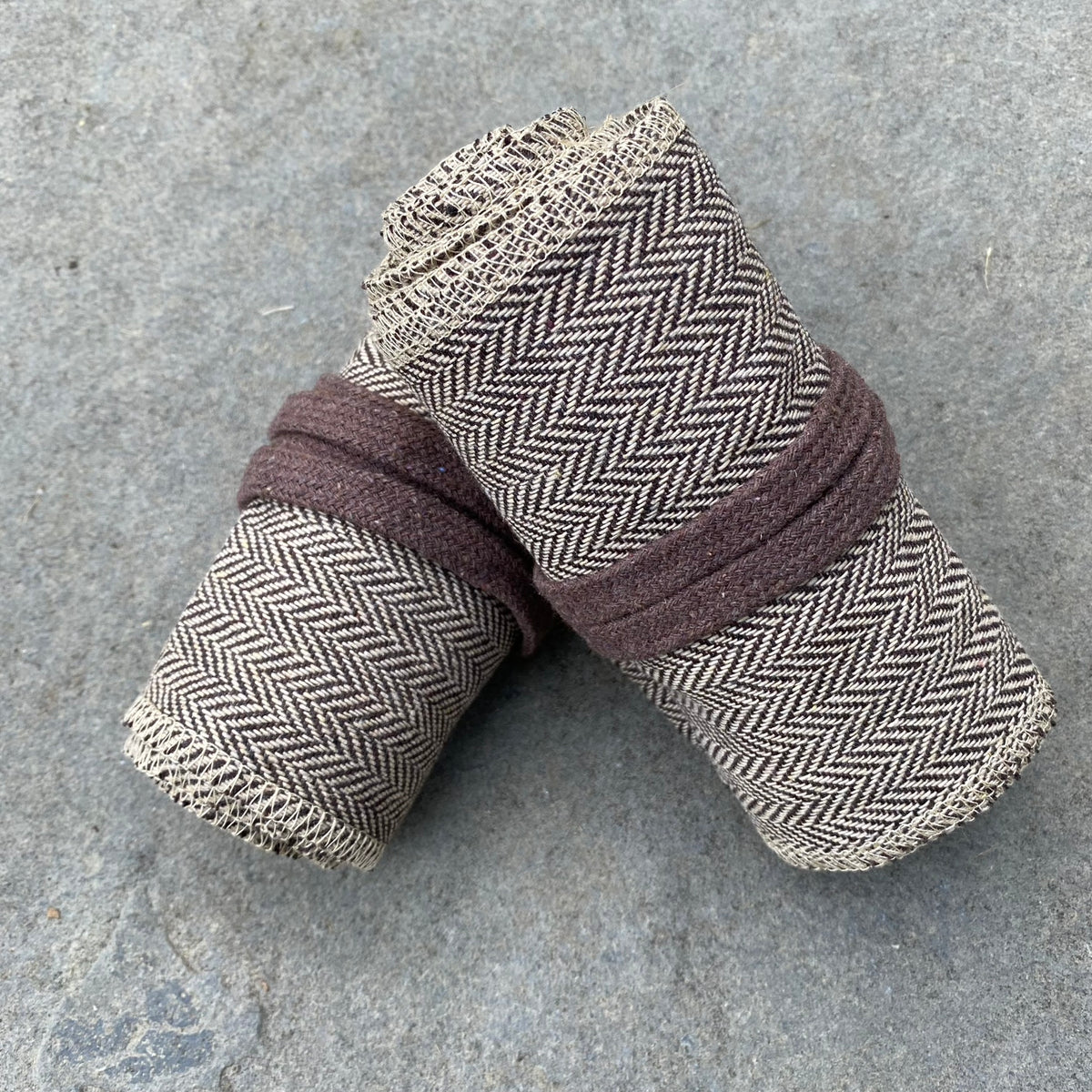Light brown herringbone LARP wraps rolled, shown on stone surface.