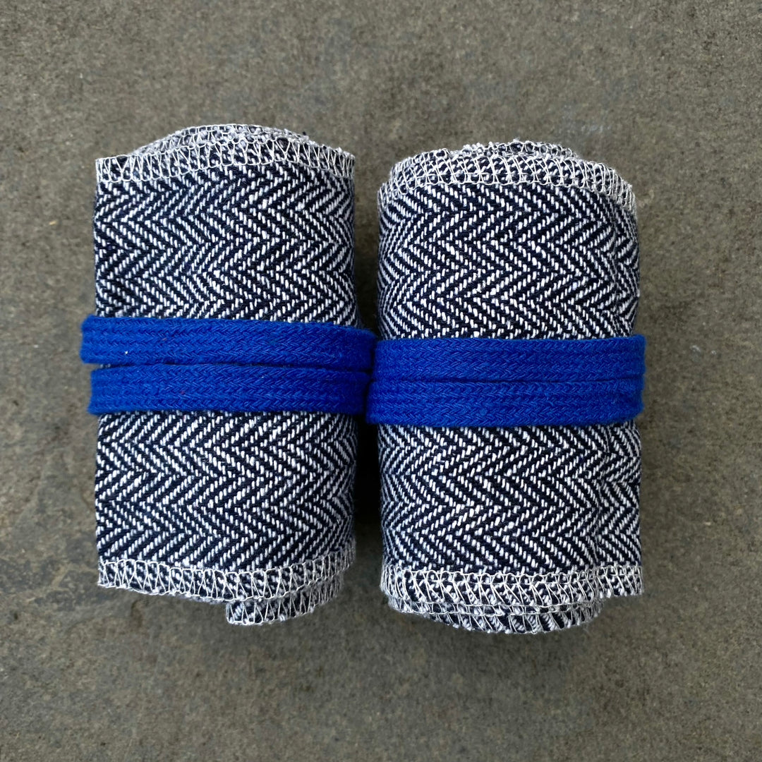 Rolled blue-white herringbone LARP wraps, close-up on grey surface.