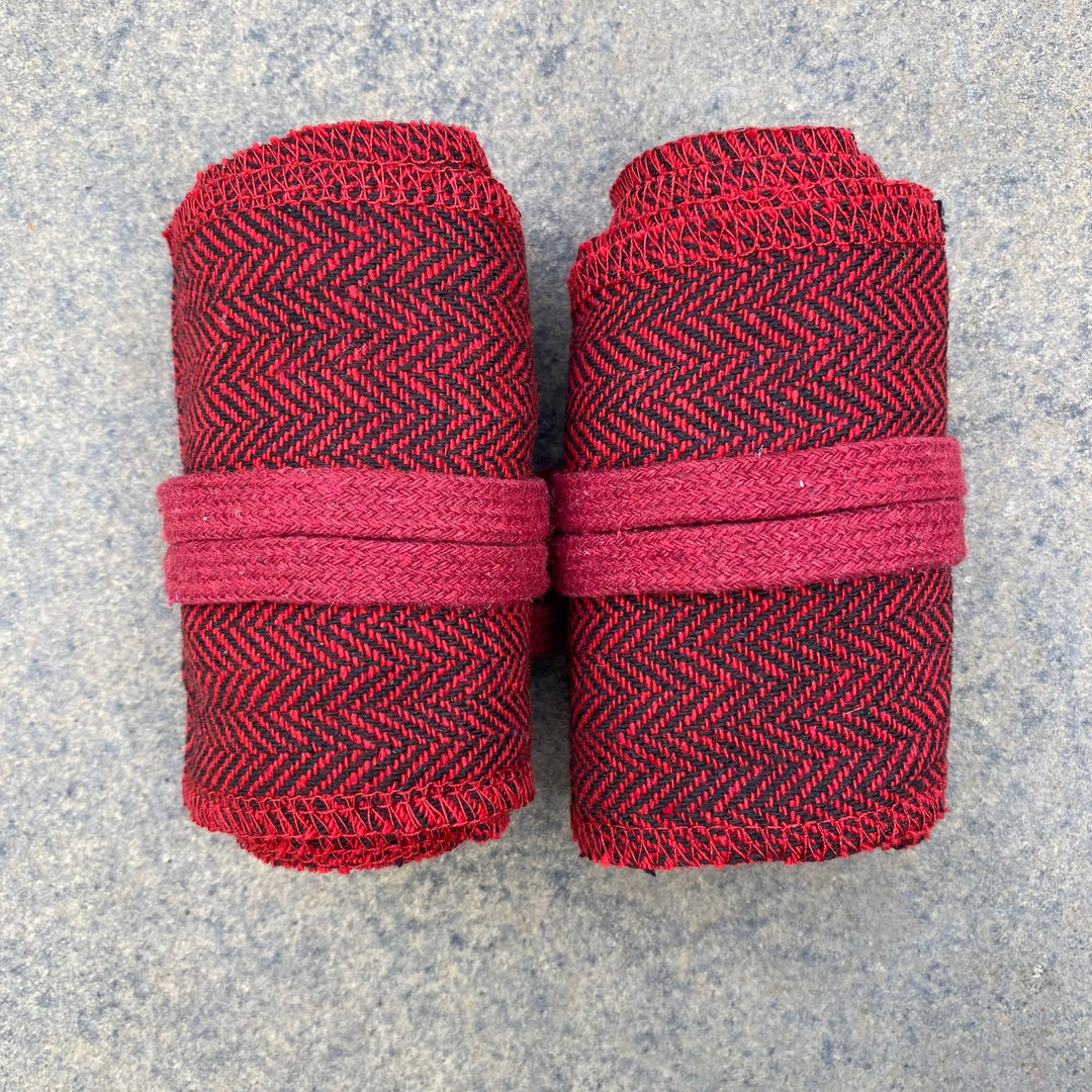 Rolled red herringbone wraps for LARP, detailed top-down view on stone surface.