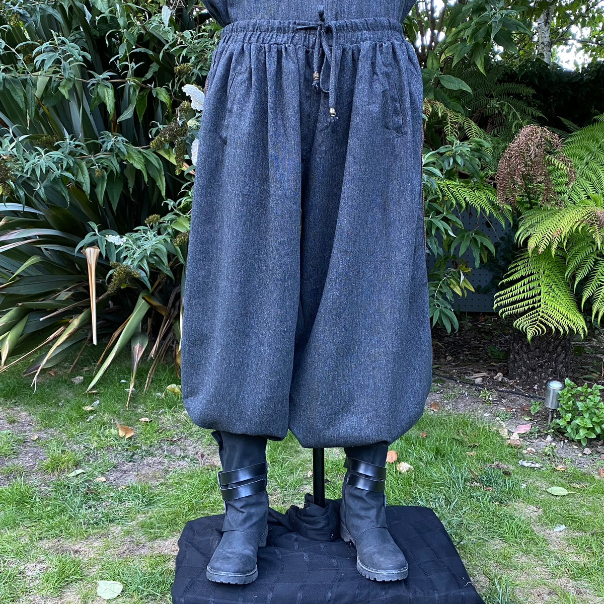 Front view of grey wool medieval hero pants with side lace detailing and braided trim.