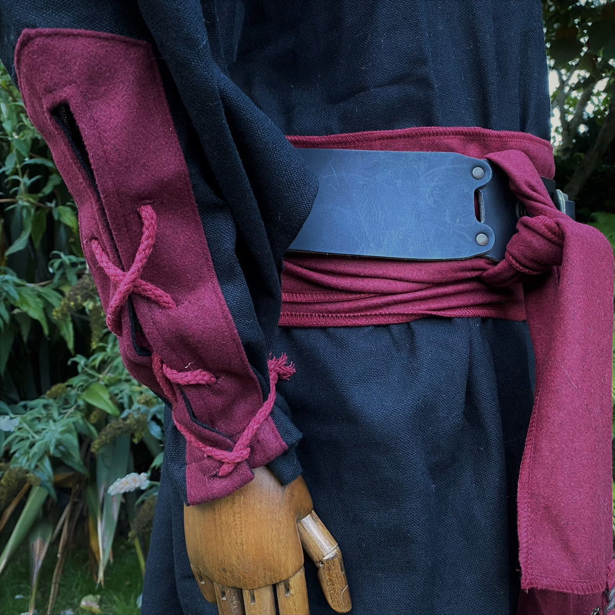 Medieval LARP costume side view, red sash and sleeve details.