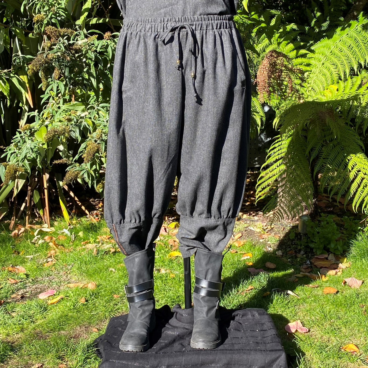 Full-length front view of braided Viking trousers paired with boots for LARP wear.