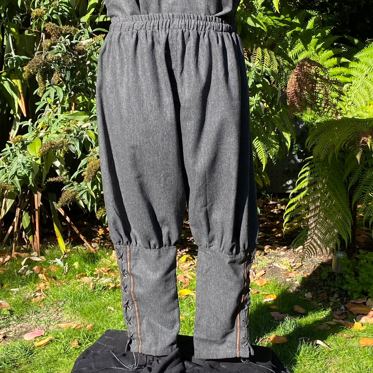 Full-length back view of grey wool Viking trousers for cosplay or medieval reenactment.