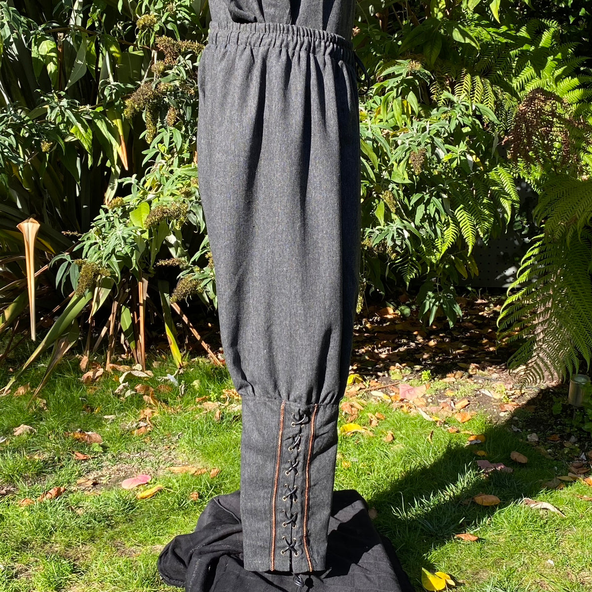 LARP medieval wool pants, front view, detailed calf braiding visible.