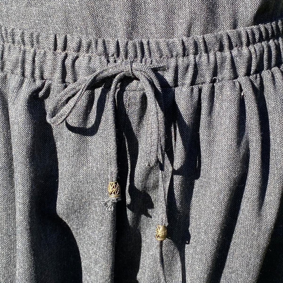 Close-up of drawstring on grey wool Viking trousers.