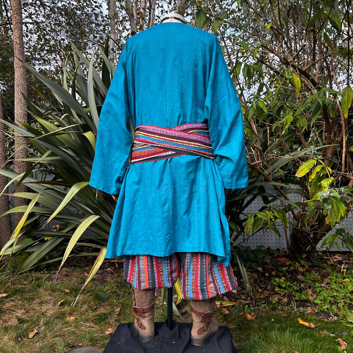Blue tunic, red-pattern pants, and striped sash, seen from the back, for LARP.