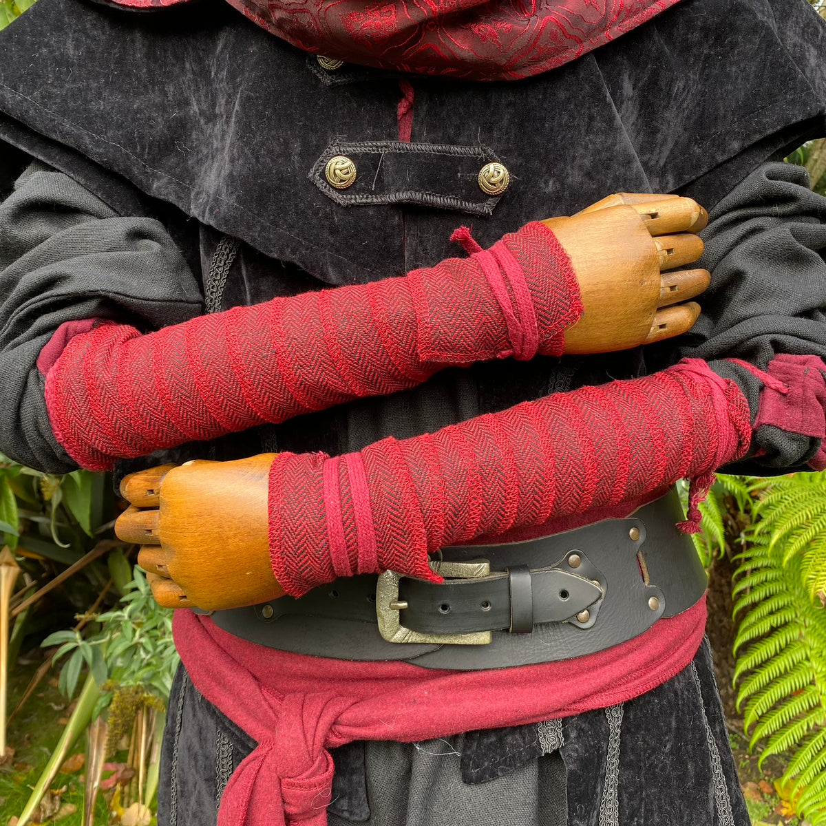 Red arm wraps and detailed belt on medieval LARP costume close-up.