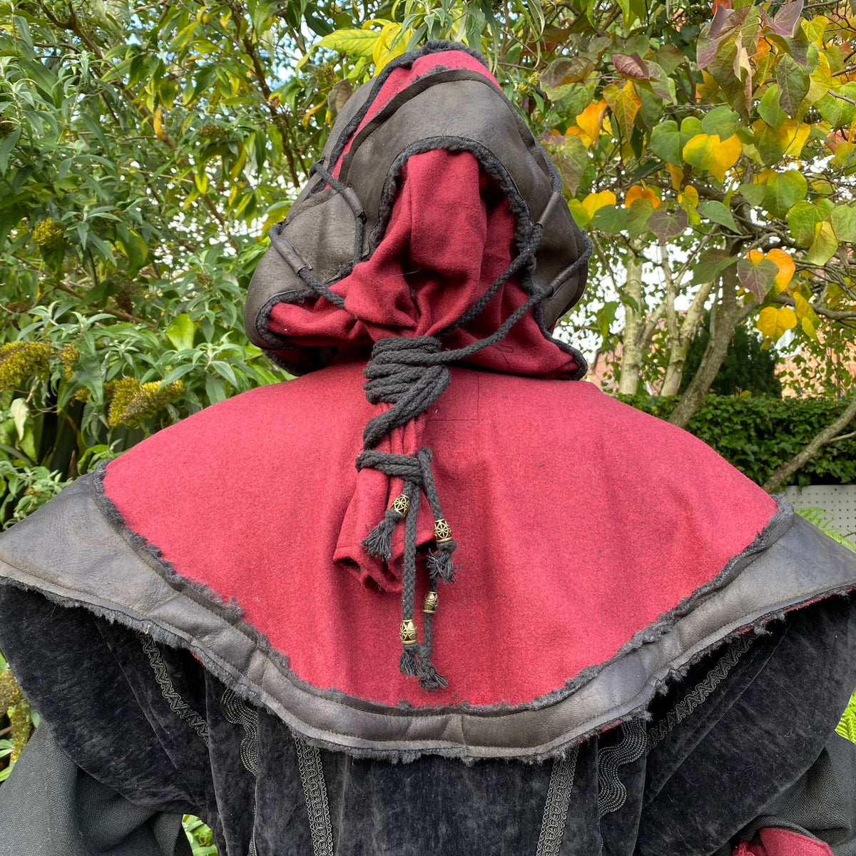 Back view of red-black layered LARP hood with tassels.