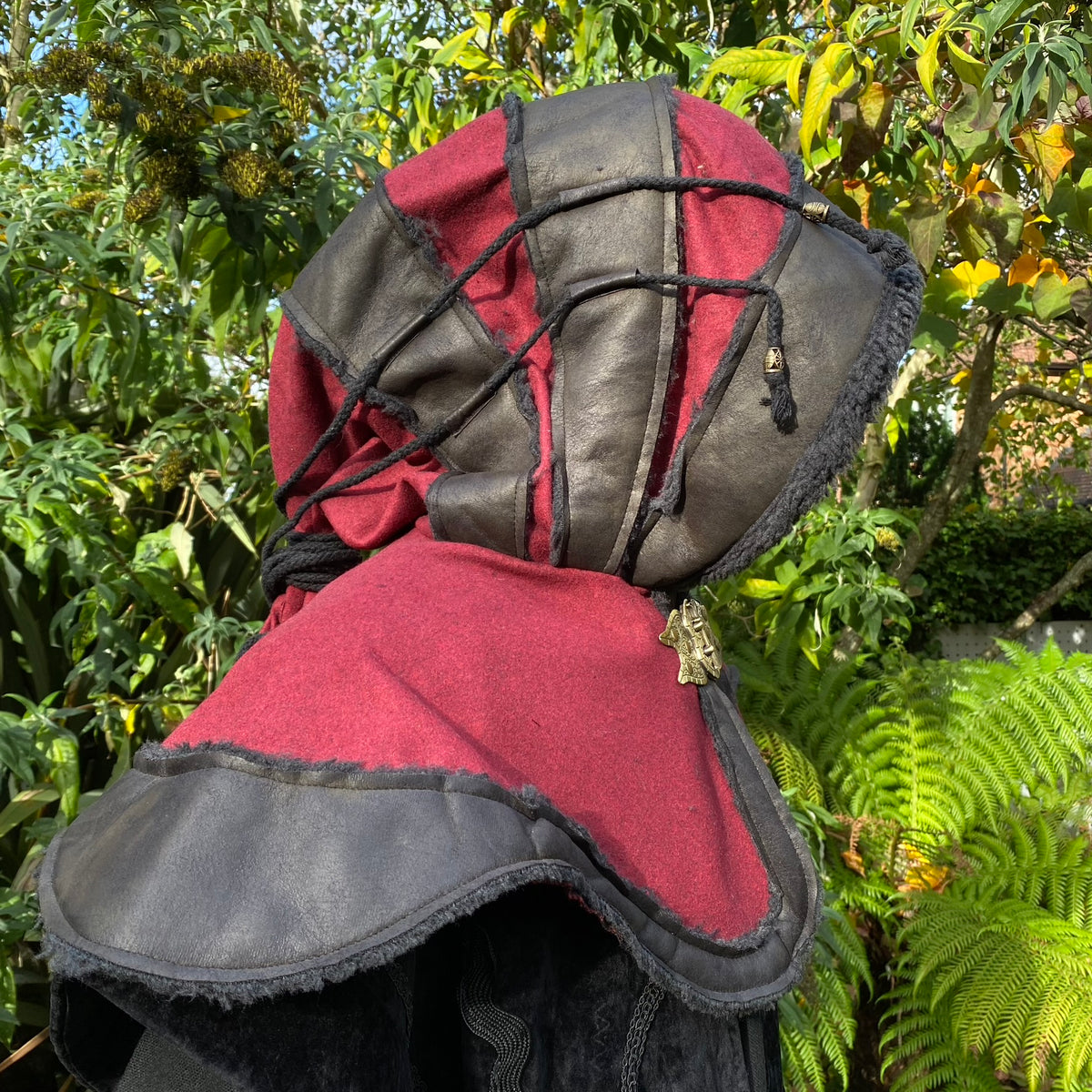 Red and black medieval LARP hood, side view, fabric with leather accents.