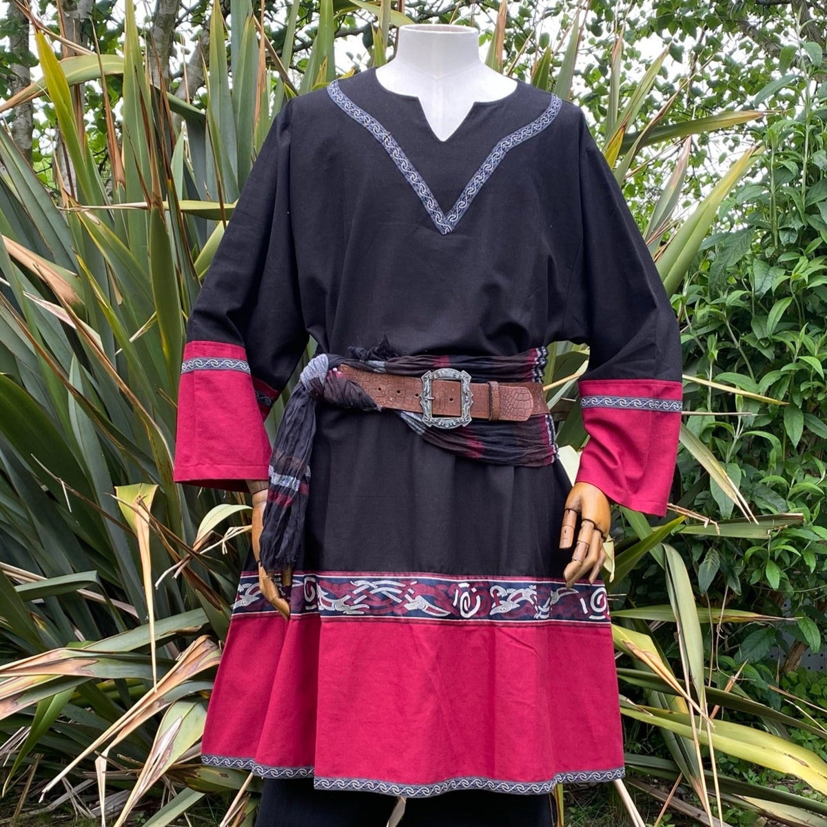 Mannequin in a black and red Viking tunic with belt.