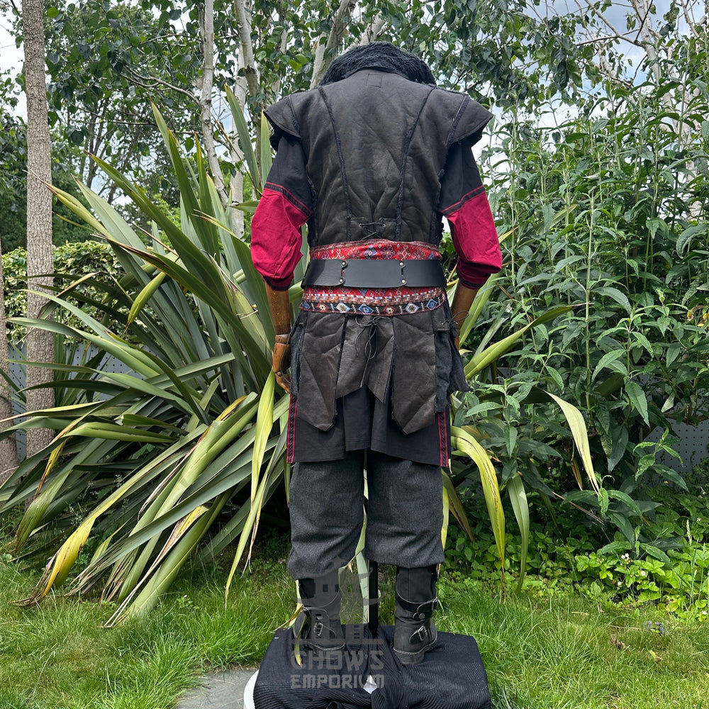 Medieval LARP outfit back view, featuring a black faux leather waistcoat, shirt, trousers and sash. For Renaissance Faire and historical roleplay events.
