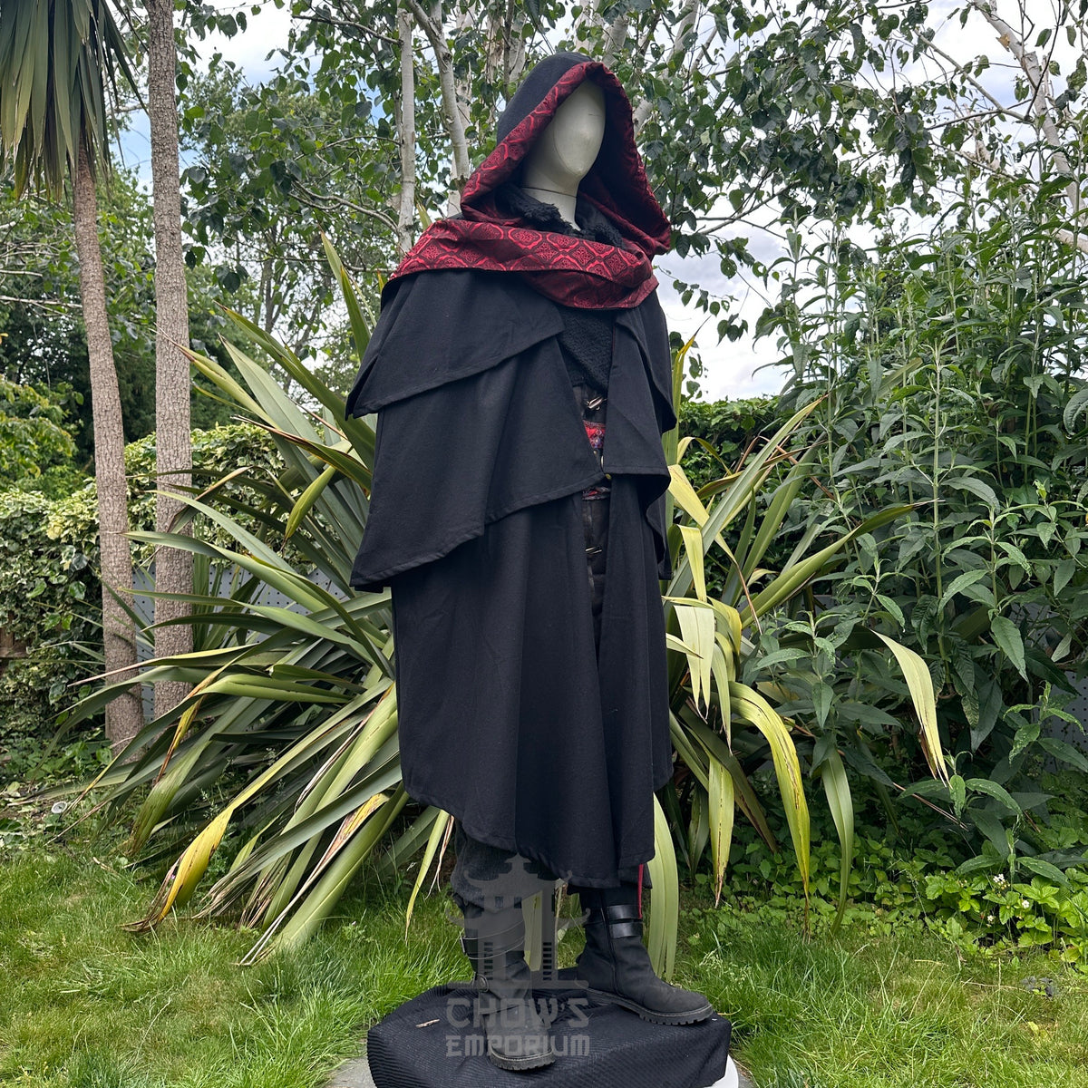 Angled hooded view of black and red medieval LARP cloak, fantasy cosplay costume with dramatic.