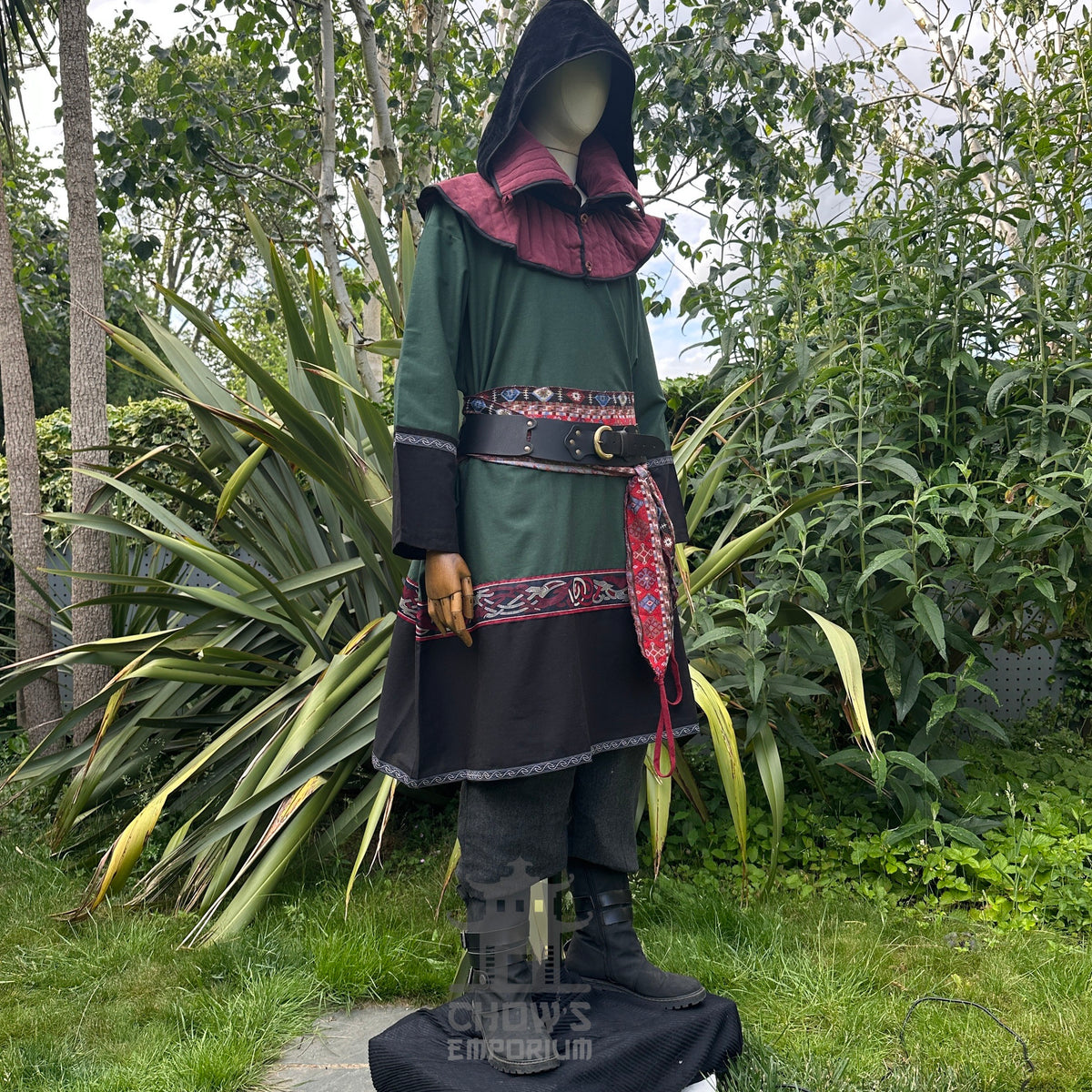 Medieval LARP outfit side view, featuring a green and black Viking tunic, gambeson hood.