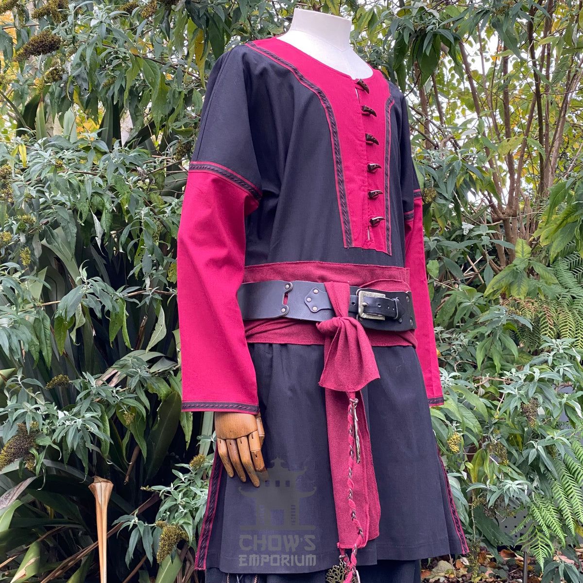 Side view of medieval LARP outfit with red accents and black belt.
