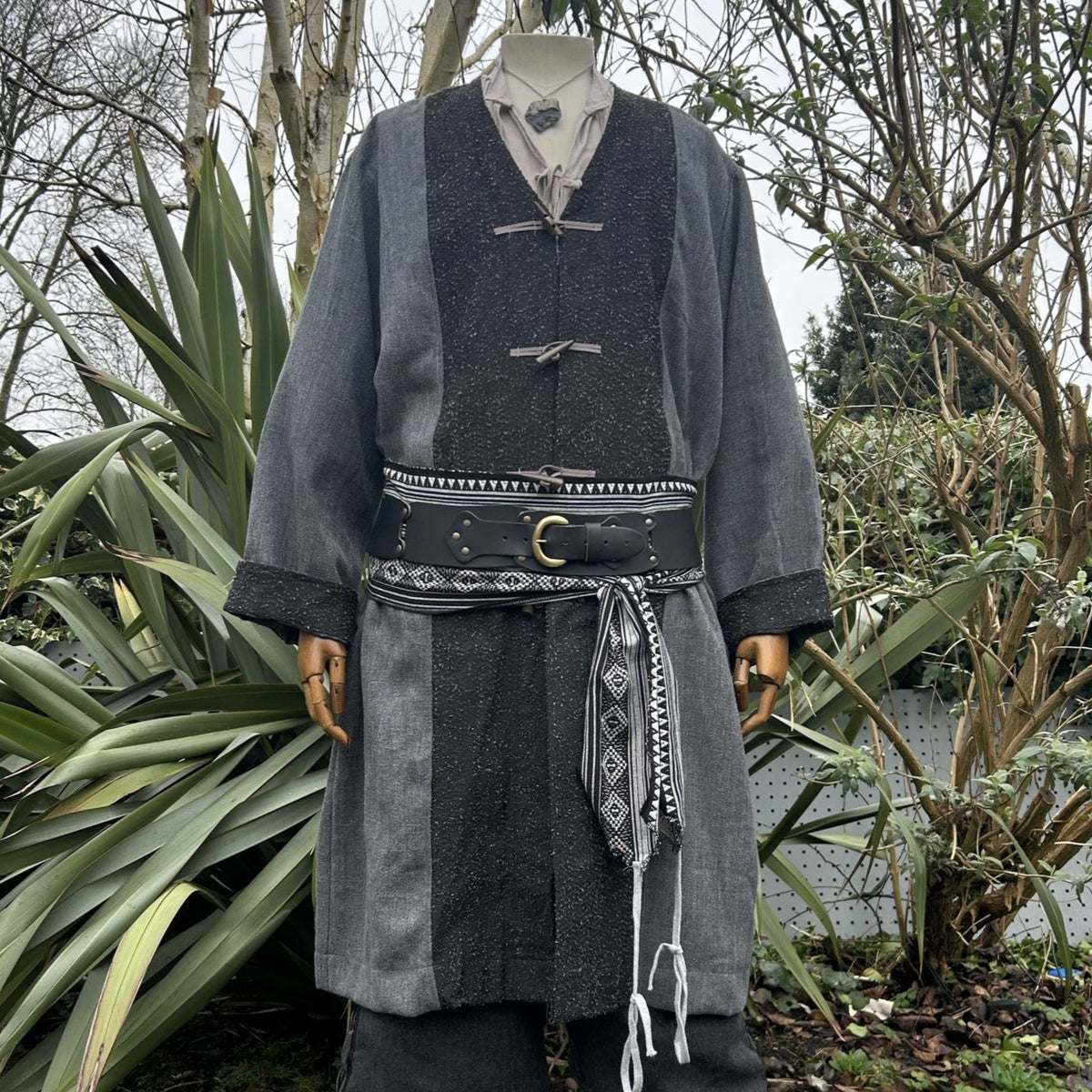 Grey and black pirate coat with belt, outdoor medieval LARP costume display.