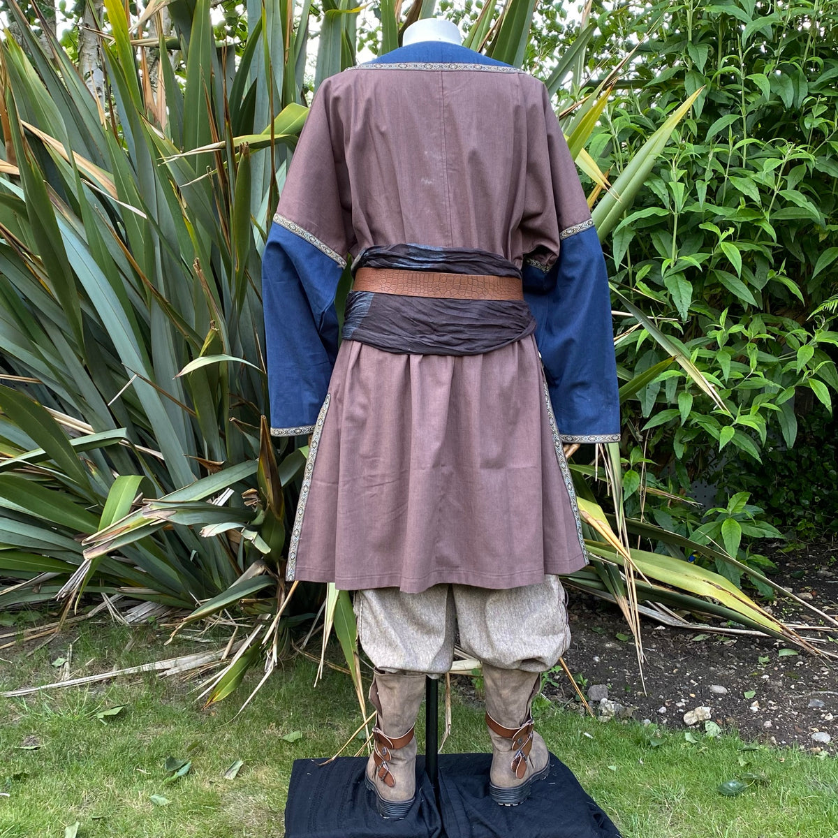 Rear view of medieval LARP tunic, brown and blue with belt detail.