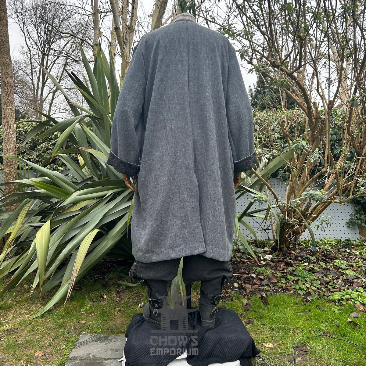 Back view of grey medieval LARP coat outdoors, showcasing wide sleeves.