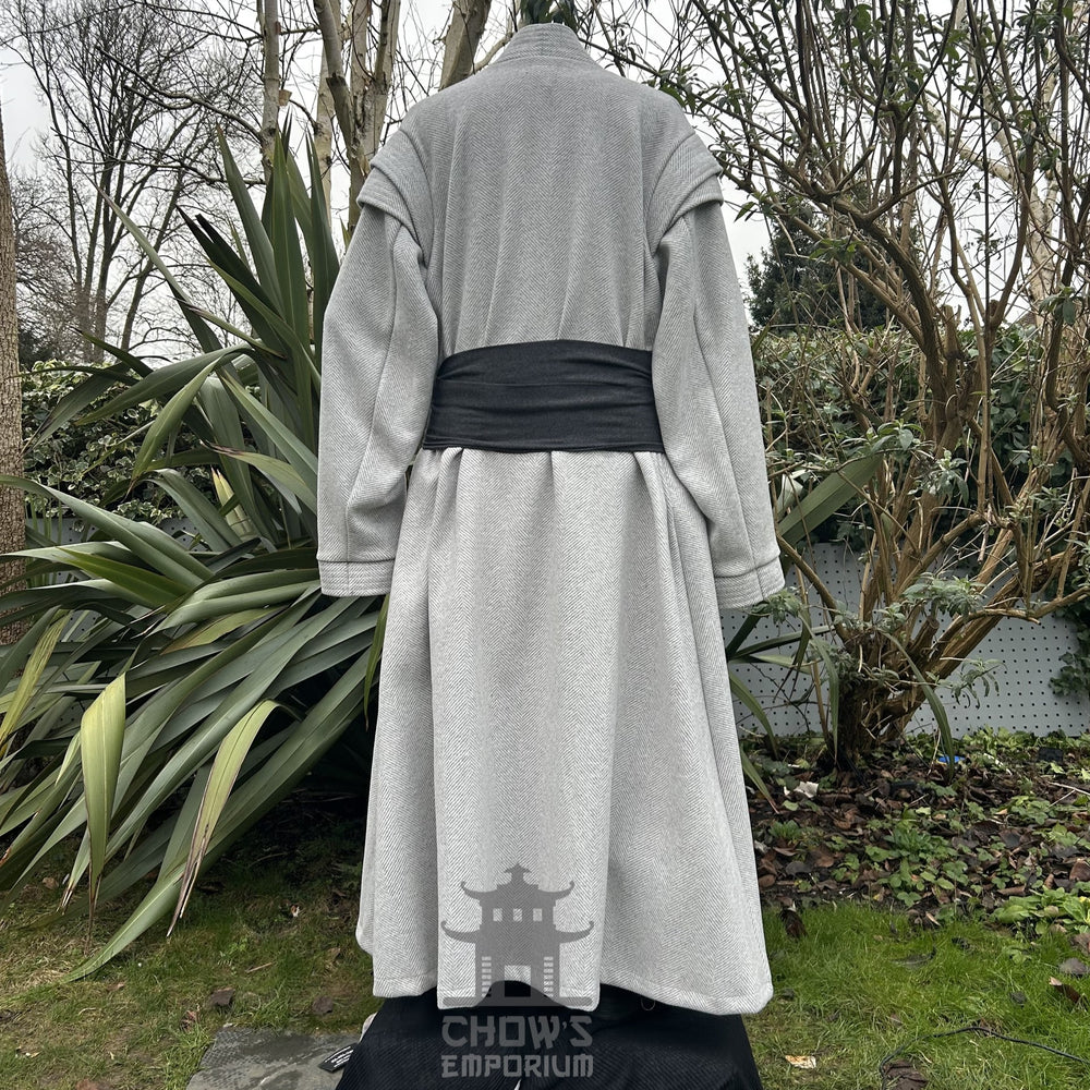 Medieval LARP costume back view, featuring a light grey full length robe, tunic, trousers, and sash. For Renaissance Faire and historical roleplay events.