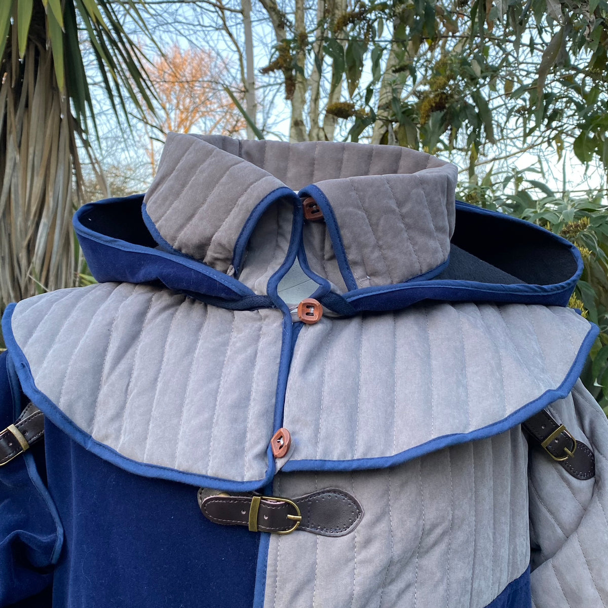 Azure and grey quilted medieval LARP jacket with hood and brass buckles.