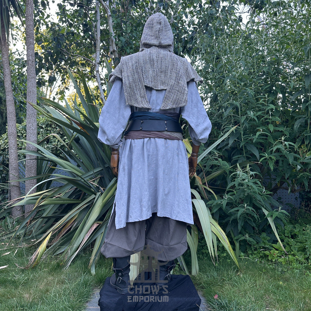 Medieval LARP outfit back view, featuring a grey cotton tunic, wrap around hood, trousers and sash. For Renaissance Faire and historical roleplay events.