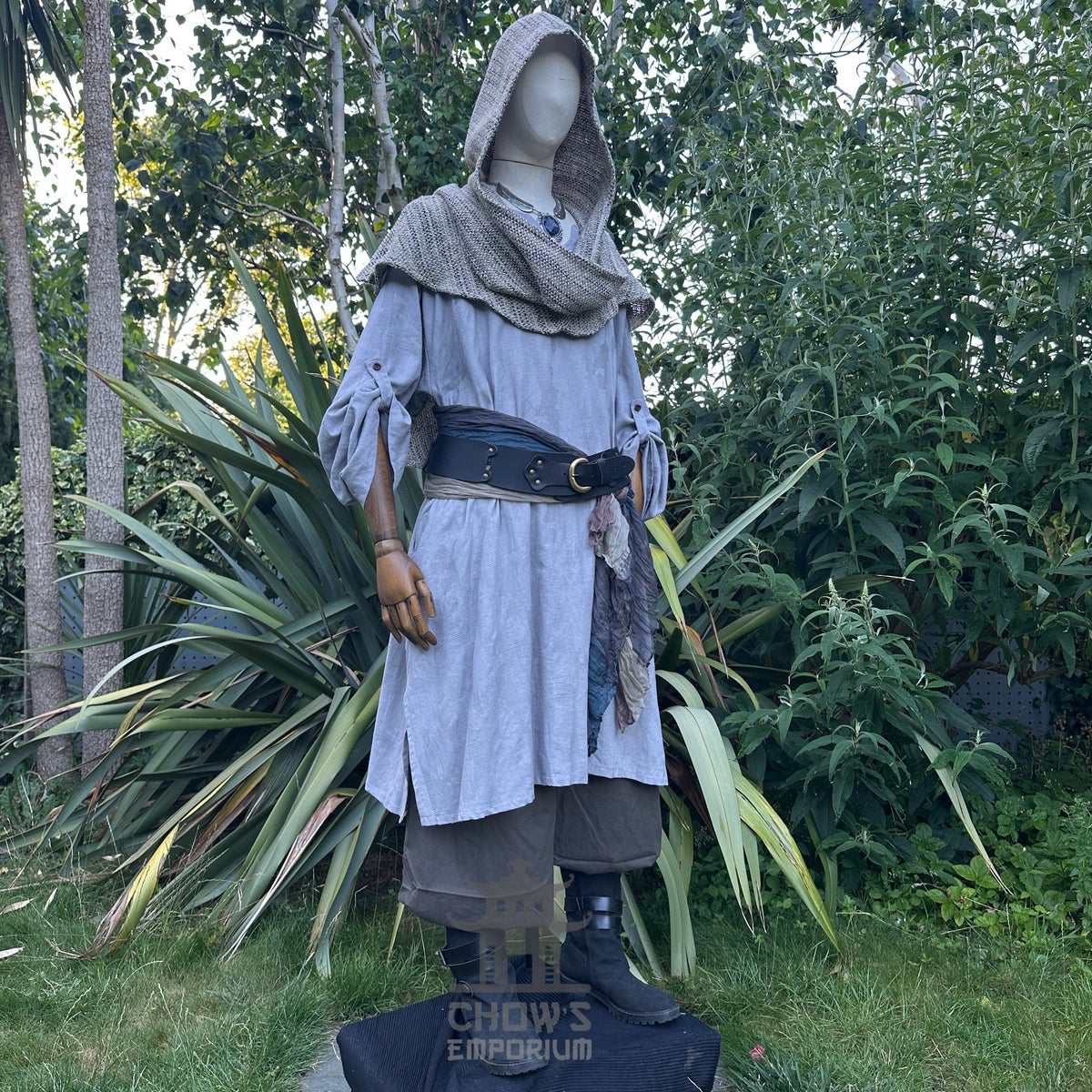 Medieval LARP outfit side view, featuring a grey cotton tunic, wrap around hood, trousers and sash.